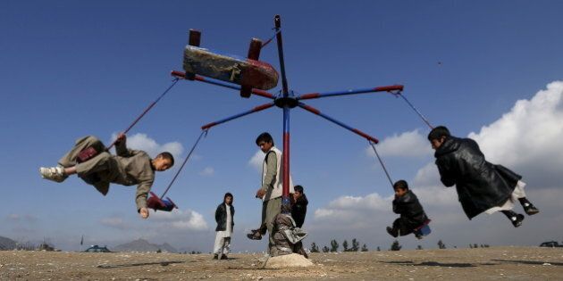 Afghan boys play on a merry-go-round during celebrations for the Afghan New Year, known as Newroz in Kabul, Afghanistan March 20, 2016. REUTERS/Mohammad Ismail