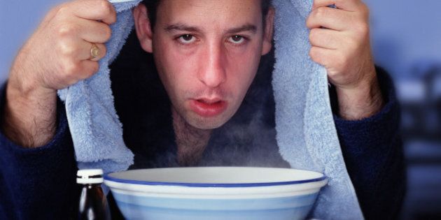 Man with towel over head, leaning over bowl of steam (Enhancement)