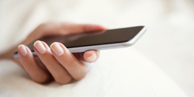 Woman using smartphone in bed