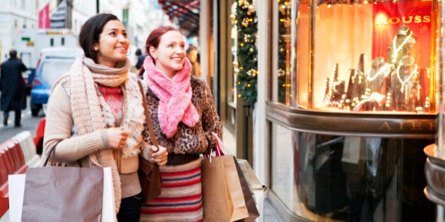 Women with shoopingbags looking at shopwindow.