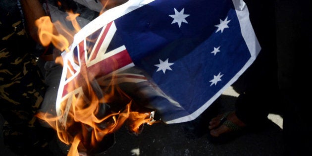 JAKARTA, INDONESIA - NOVEMBER 21: Indonesian activists burn the Australian Flag during a rally in front of the Australian embassy on November 21, 2013 in Jakarta, Indonesia. Approximately 200 demonstrators gathered at the Australian embassy in Jakarta in protest over reports the Australian government attempted to tap the phones of Indonesian President Susilo Bambang Yudhoyono in 2009. (Photo by Nurcholis Anhari Lubis / Getty Images)