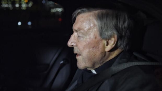 Cardinal George Pell leaving the airport escorted by police.