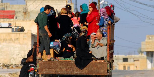 Civilians sit on a pick-up truck with their belongings in Taybat al Imam town after rebel fighters from the hardline jihadist Jund al-Aqsa advanced in the town in Hama province, Syria August 31, 2016. REUTERS/Ammar Abdullah