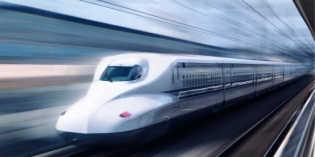 Shinkansen high-speed bullet train N700 series Nozomi passing a platform blurred from motion. Shizuoka, Japan