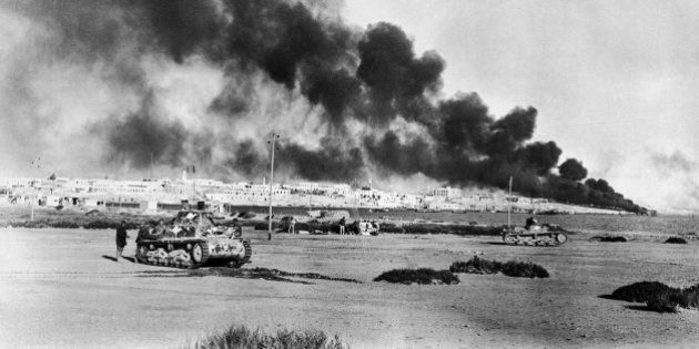 Tobruk, strategic Libyan port abandoned by the Nazis, was reoccupied by the British, Nov. 13, 1942. This photo shows Tobruk harbor and the city beyond, with fires burning, when it was previously captured by British forces early in 1941. British tanks wait in foreground. (AP Photo)