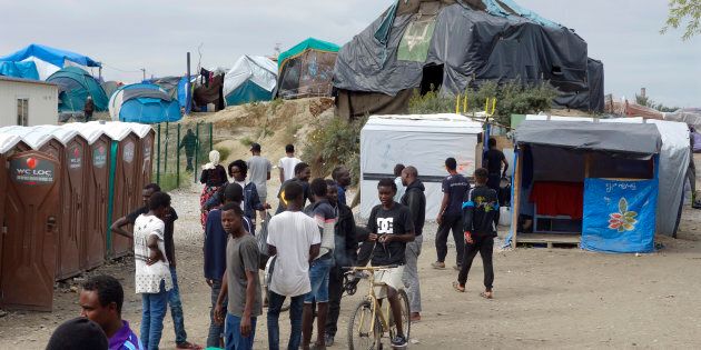 Migrants walk in the northern area of the camp called the