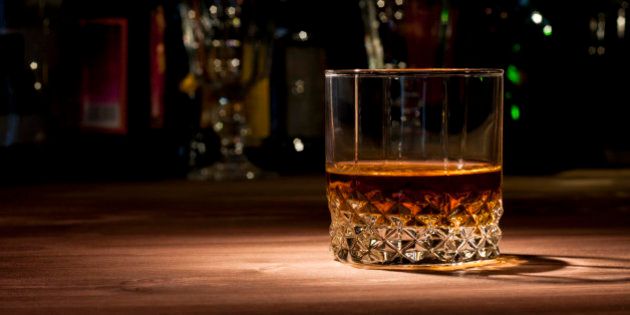 Glass of whiskey on a wooden table in the bar