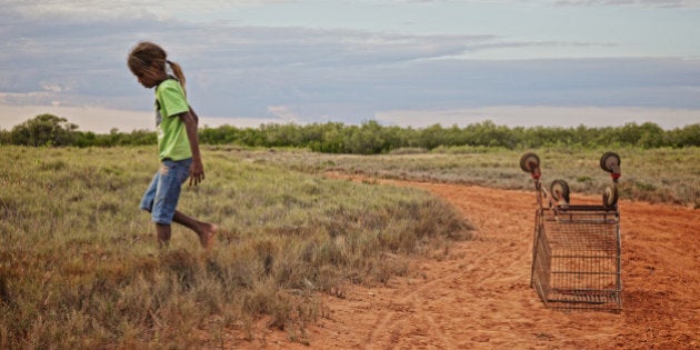 Aboriginal girl with supermarket trolly.