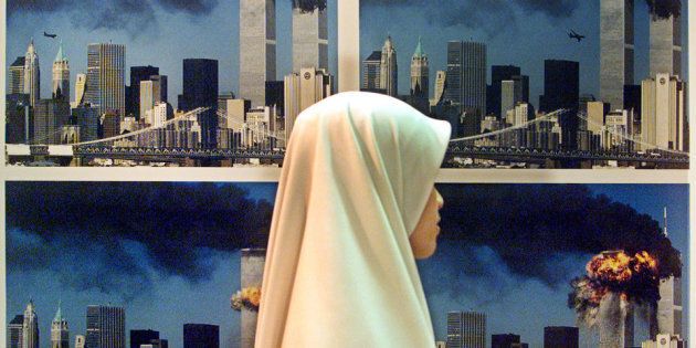 A Malaysian Muslim woman walks past a display of photos showing UnitedAirlines flight 175 crashing into the World Trade Center South Tower ata gallery in Kuala Lumpur September 25, 2002. Two hundred award-winningimages taken in 2001 are currently on display in Malaysia's NationalArt Gallery. The background photos in this image were taken by U.S.photographer Robert Clark. REUTERS/Bazuki MuhammadBM/PB