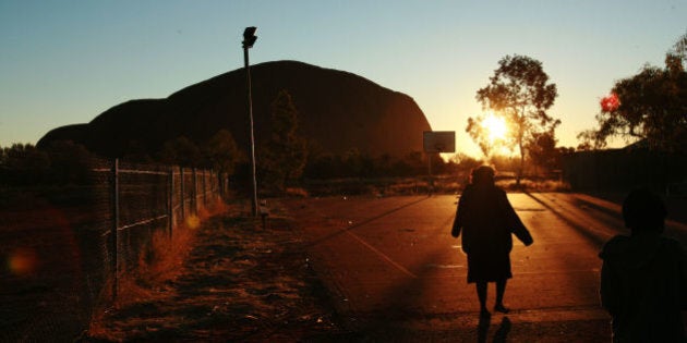 A child plays at sunset in the Aboriginal community of Mutitjulu, in the shadow of Uluru, in the Northern Territory. The town is the first to be targeted in the Australian government's campaign to stamp out child abuse in remote indigenous communities. Australian Prime Minister John Howard says the permit system in the Northern Territory restricting entry to such communities had kept them 'out of view and out of mind', hindering efforts to tackle their problems, 26 June 2007. (Photo by Jason South/The AGE/Fairfax Media via Getty Images)