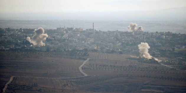 Smoke from explosions rises during fighting in the village of Jubata Al Khashab, held by Syrian rebel groups fighting to overthrow President Bashar al-Assad.