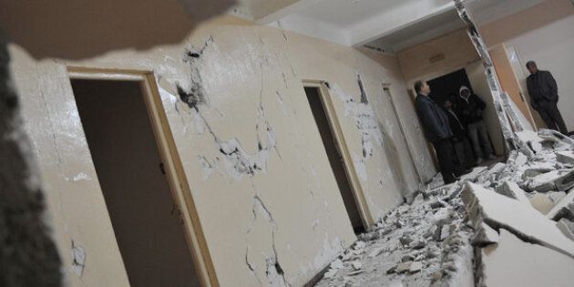 Algerian men inspect a damaged clinic building following an earthquake in Beni Yellman village, 260 km east of Algiers, on May 14, 2010. A moderate earthquake in Algeria on Friday killed two people and injured 43 others, the interior ministry reported. AFPP HOTO/FAYEZ NURELDINE (Photo credit should read FAYEZ NURELDINE/AFP/Getty Images)