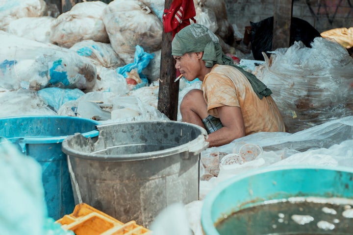 A man sorts through mounds of rubbish.