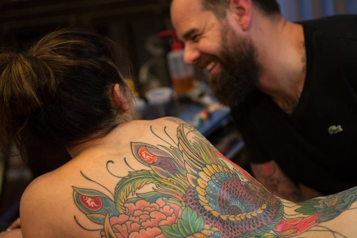 Kian Forrea, tattoo artist and founder of Authentink "vibing" with a client.