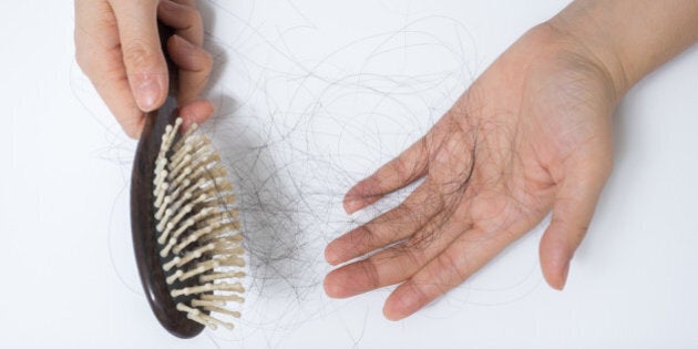 Hair loss in woman hands and bruch, on white background, women postpartum defluvium