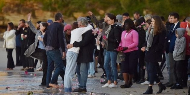 Justine Damond's parents John and Maryan Ruszczyk hug at the shore of Sydney's Freshwater Beach.