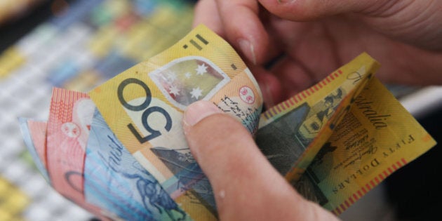 MELBOURNE, AUSTRALIA - NOVEMBER 07: A bookie counts up dollar notes on Stakes Day at Flemington Racecourse on November 7, 2015 in Melbourne, Australia. (Photo by Michael Dodge/Getty Images)