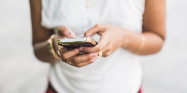 Cropped shot of young woman texting on smartphone