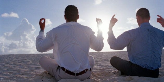 Bahamas, two businessmen meditating on beach, rear view