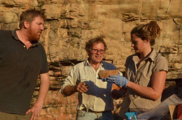 Lead archaeologist Chris Clarkson with Richard Fullagar and Elspeth Hayes examining a rare grindstone from the lowest layers of the excavation.