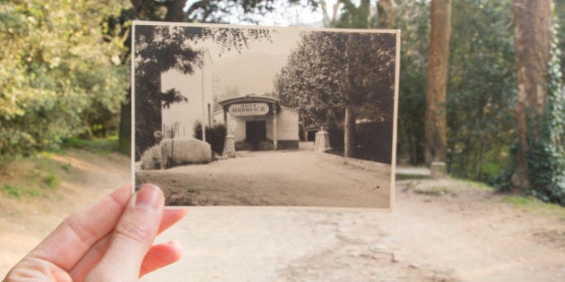 Comparison of Now and Then with picture on black and white fitting on the actual scenario with all the time changes, holding the picture by hand and from personal point of view. Old building of Manantial Burriac that doesn't exist actually. Font Picant, Argentona, Catalonia, Europe.