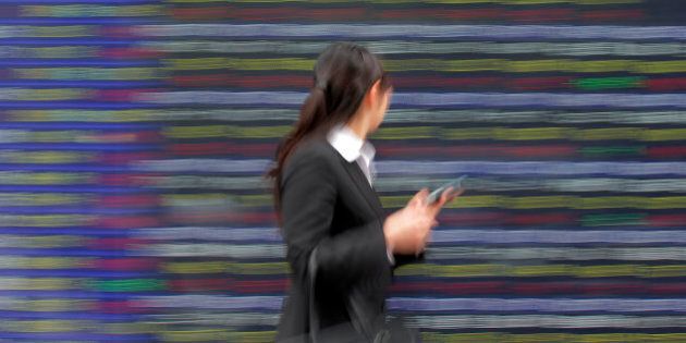 A woman walks past the electronic stock board of a securities firm in Tokyo Wednesday, June 6, 2012. Asian stock markets perked up Wednesday after U.S. service companies, which employ most of the American workforce, grew at a slightly faster pace in May. (AP Photo/Itsuo Inouye)