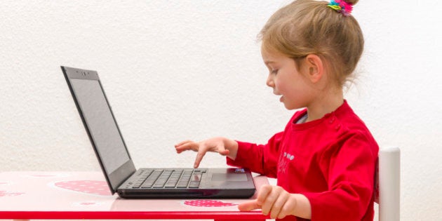 WUERZBURG, BAVARIA, GERMANY - 2014/12/21: A blond three year old girl is sitting in front of a notebook, laptop, watching the screen and using the keyboard. (Photo by Frank Bienewald/LightRocket via Getty Images)