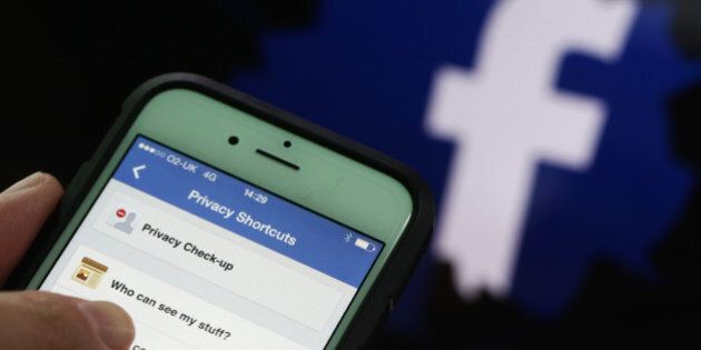 Privacy setting shortcuts are displayed on Apple Inc. iPhone 6 smartphone screen as a FaceBook Inc. logo is seen in this arranged photograph taken in London, U.K., on Friday, May, 15, 2015. Facebook reached a deal with New York Times Co. and eight other media outlets to post stories directly to the social network's mobile news feeds, as publishers strive for new ways to expand their reach. Photographer: Chris Ratcliffe/Bloomberg via Getty Images