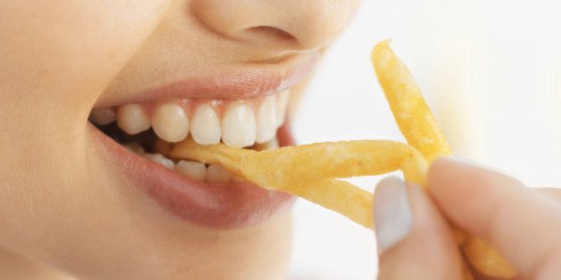 Close-up of a woman eating fries