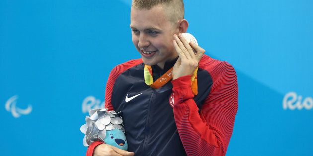 RIO DE JANEIRO, BRAZIL - SEPTEMBER 10: Silver medalist Tharon Drake of the United States listens to the sound of his medal on the podium at the medal ceremony for the Men's 400m Freestyle - S11 on day 3 of the Rio 2016 Paralympic Games at the Olympic Aquatic Stadium on September 10, 2016 in Rio de Janeiro, Brazil. (Photo by Buda Mendes/Getty Images)