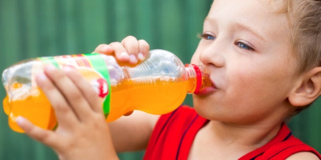 Boy drinking unhealthy bottled soda