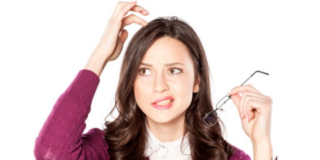 Thoughtful young woman scratching her head