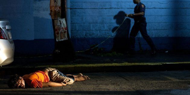 The body of a man, shot dead by unidentified gunmen, lies on the ground in Manila on July 23, 2016.