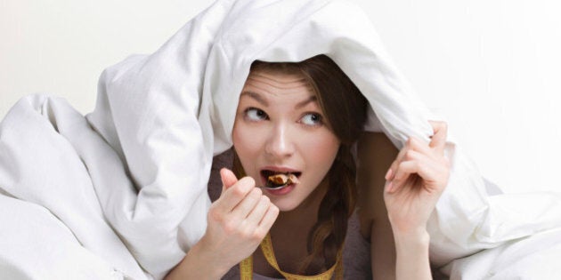 young beauty woman eating dessert under cover on white background