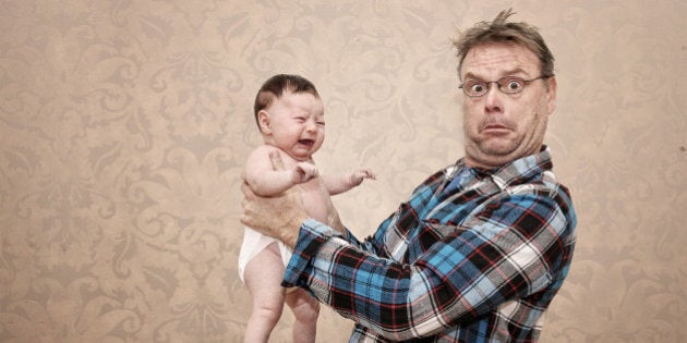 Father Holding his Young Baby with a Surprised and Confused Expression