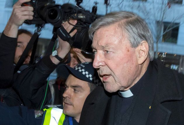 Cardinal George Pell is surrounded by police and members of the media as he arrives at the Melbourne Magistrates Court in Australia, July 26, 2017.