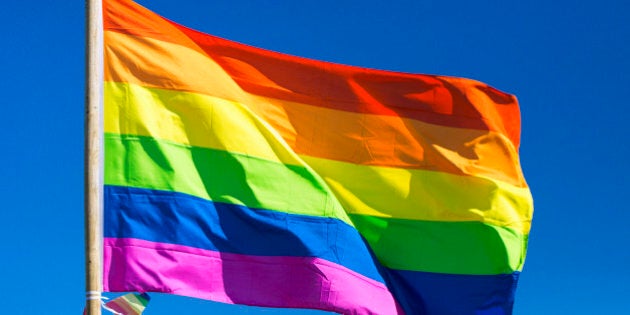 Rainbow flag against sky during gay pride parade