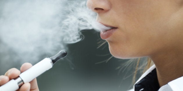 closeup of woman smoking e-cigarette and enjoying smoke. Copy space