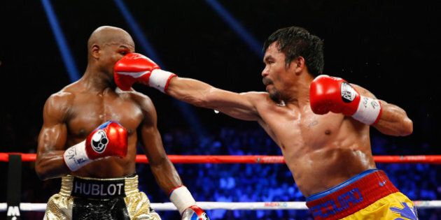 LAS VEGAS, NV - MAY 02: Manny Pacquiao throws a right at Floyd Mayweather Jr. during their welterweight unification championship bout on May 2, 2015 at MGM Grand Garden Arena in Las Vegas, Nevada. (Photo by Al Bello/Getty Images)