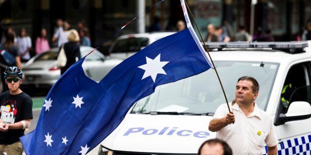 MELBOURNE, AUSTRALIA -- JANUARY 26, 2017: A protestor waves the Australian Flag with the Union Jack removed during a protest, organised by Aboriginal rights activists on Australia Day.