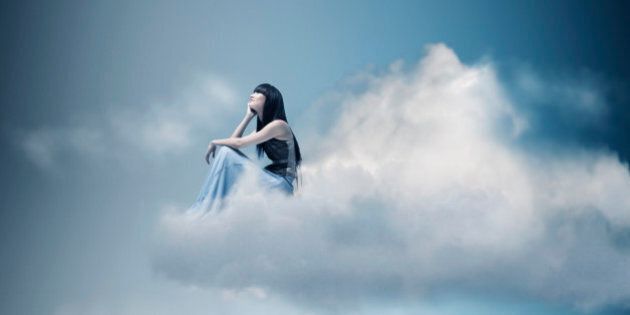 Woman sitting and thinking on a cloud.