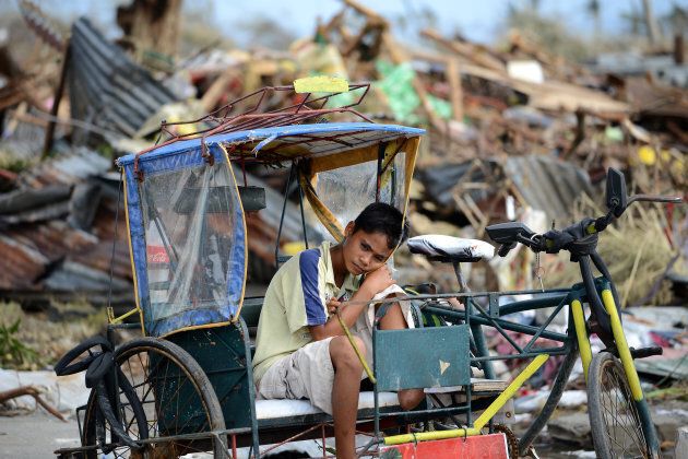 A young survivor surrounded by debris caused by Super Typhoon Haiyan in Tacloban in the eastern Philippine island of Leyte on November 11, 2013.