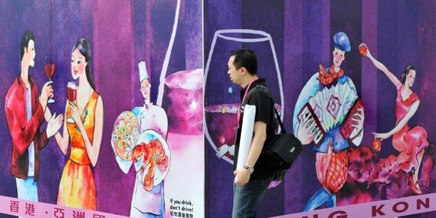 A man walks past a billboard advertising the upcoming Hong Kong Wine and Dine Festival in Hong Kong on October 27, 2011. With 211 wine exhibitors this year, up from 172 last year, organisers at the Tourism Board are hoping the festival's third annual edition will further establish Hong Kong's status as Asia's wine and fine dining hub. AFP PHOTO / LAURENT FIEVET (Photo credit should read LAURENT FIEVET/AFP/Getty Images)