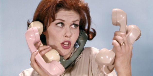 1960s FRUSTRATED YOUNG REDHEADED WOMAN TRYING TO ANSWER HANDLE FIVE TELEPHONE RECEIVERS STUDIO (Photo by H. Armstrong Roberts/ClassicStock/Getty Images)