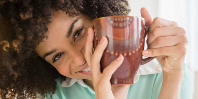 Mixed race woman drinking cup of coffee