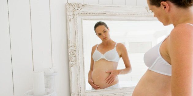 Pregnant woman by mirror