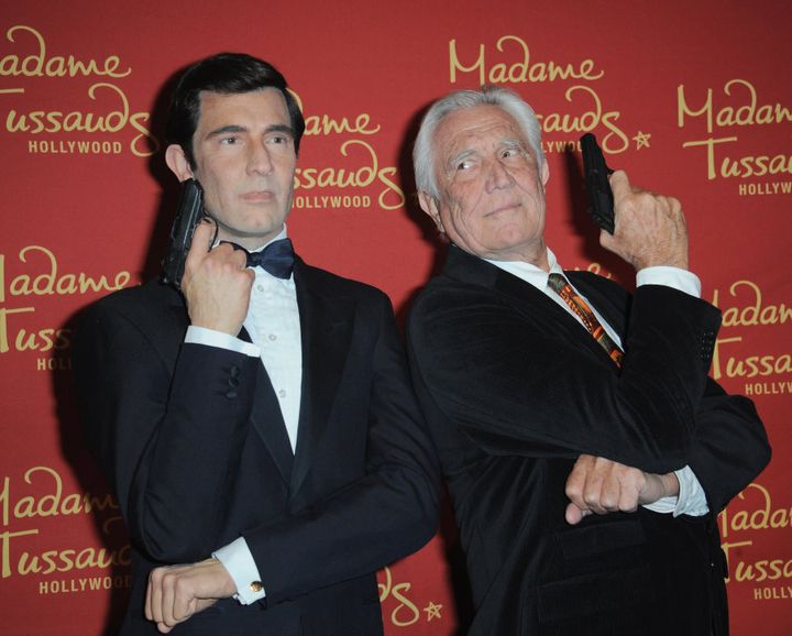 George Lazenby poses with a wax sculpture of his rendition of James Bond.