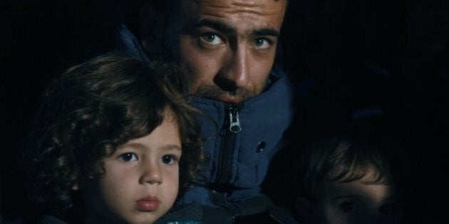 A Syrian man wait with his children near the highway on September 16, 2015, on their way to the border between Turkey and Greece. Around 1,000 refugees remained stranded September 16 in the northwestern Turkish city of Edirne, near the Greek border, after being barred by Turkish authorities from continuing their journey to Europe. AFP PHOTO/BULENT KILIC (Photo credit should read BULENT KILIC/AFP/Getty Images)