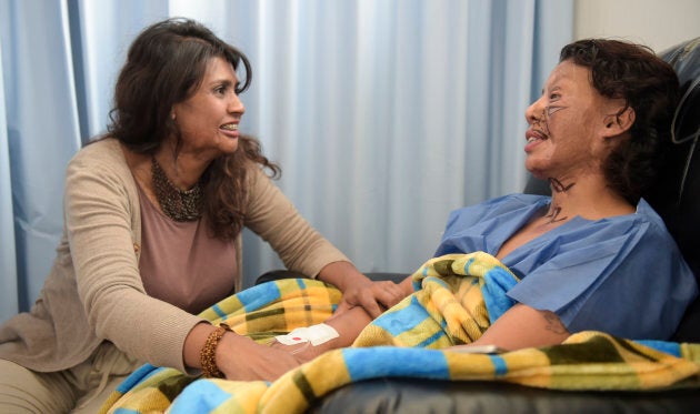 Angeles Borda (R), who survived an acid attack ten years ago, is reassured by Gina Potes, the victim of the first reported acid attack in Colombia 20 years ago, ahead of Borda's surgery with Dr. Alan Gonzalez in Bogota, Colombia on May 30, 2017.