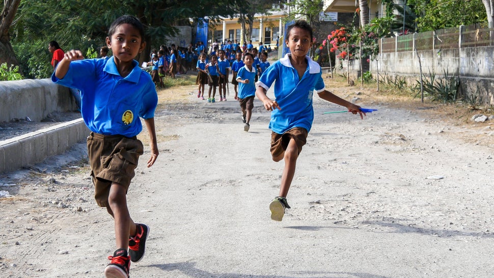 Caught in a kid-stampede as these boys got some serious air making their way down to see riders come in at Tour de Timor 2016. Baucau, Timor-Leste.